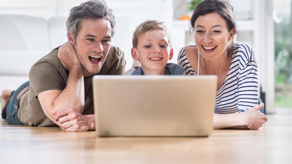 Una familia sonríe frente al ordenador