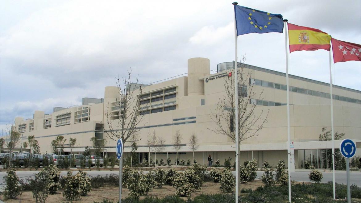 Fachada de un hospital junto a banderas institucionales