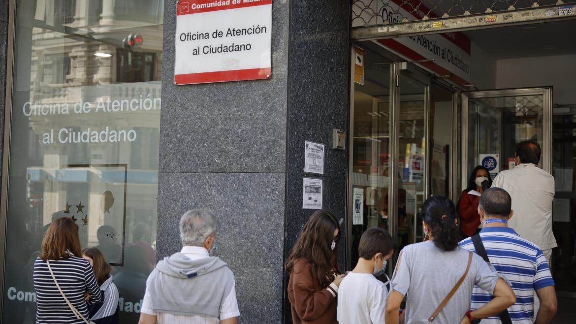 Imagen de la entrada de la Oficina de Atención al Ciudadano de Gran Vía con personas esperando a las puertas