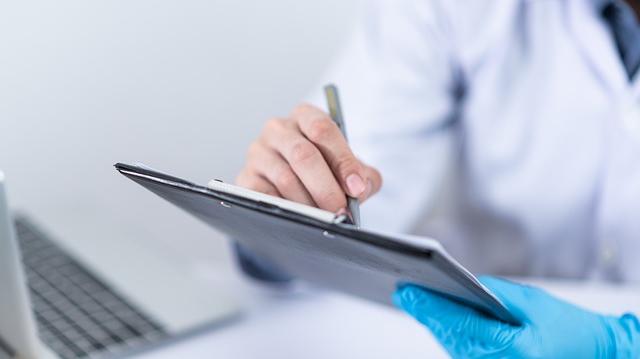 personal sanitario con bata con una tablet en la mano