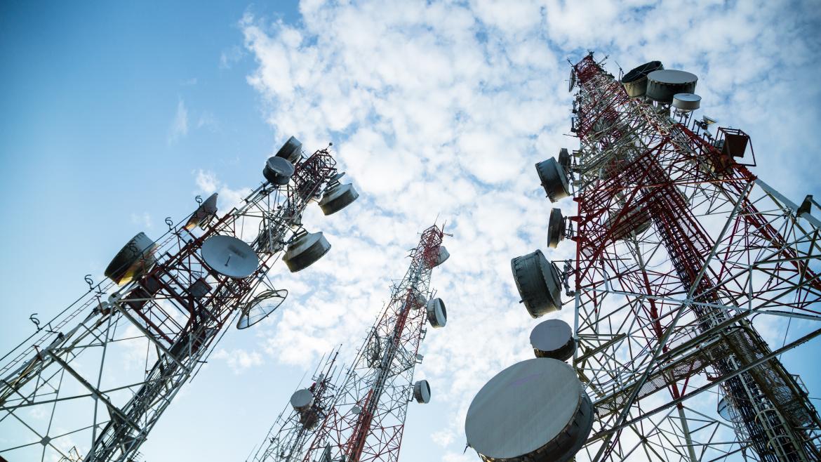 Tres antenas de telecomunicaciones y el cielo con nubes