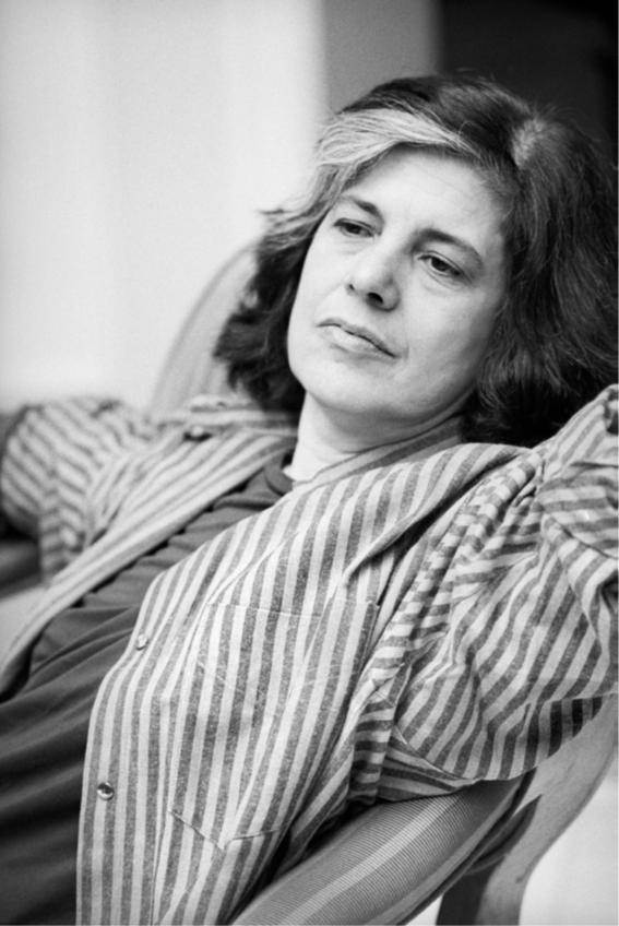 Portrait of a female writer sitting, looking at the horizon and wearing a striped shirt