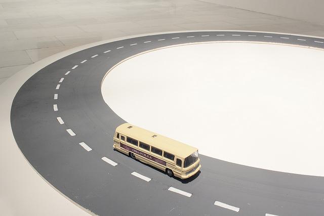 Artistic installation that simulates a road and a yellow toy bus on it