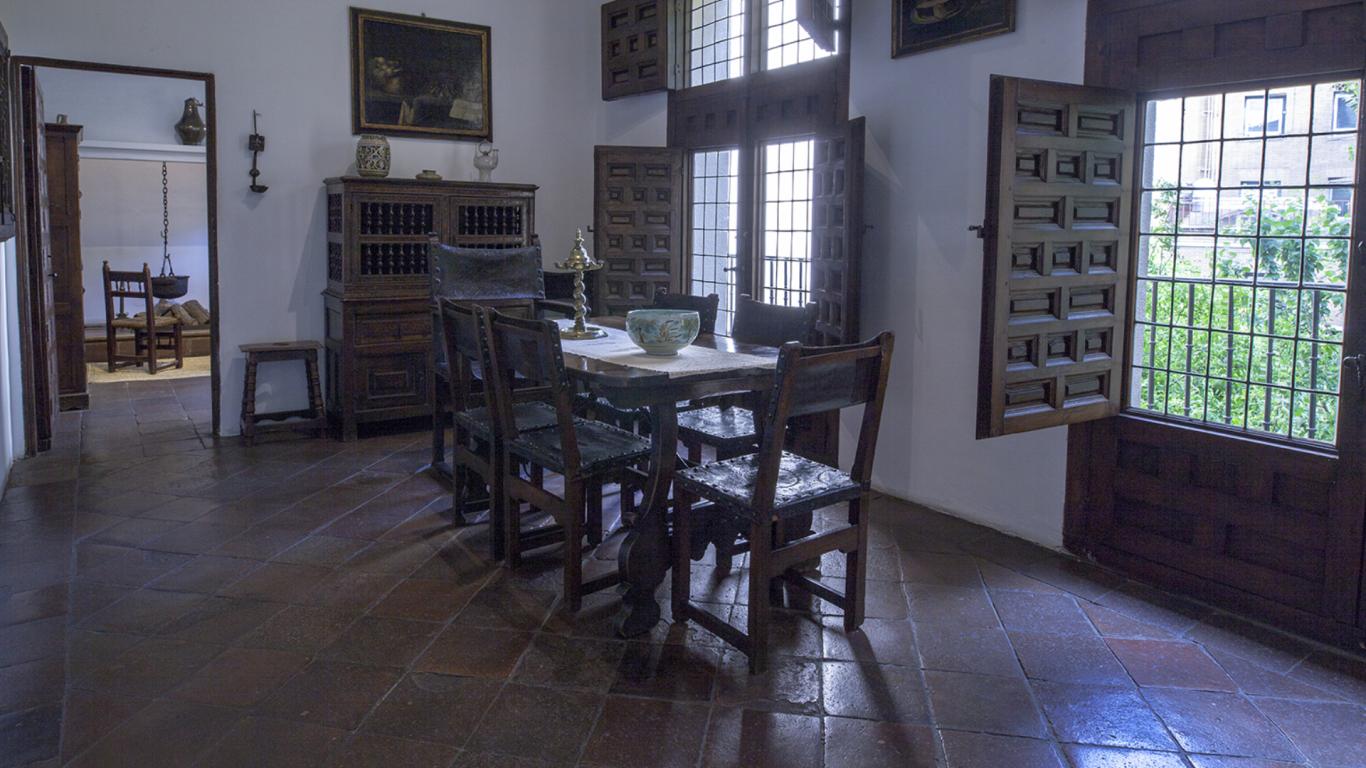 Sala de comer con mesa y sillas de madera antiguas