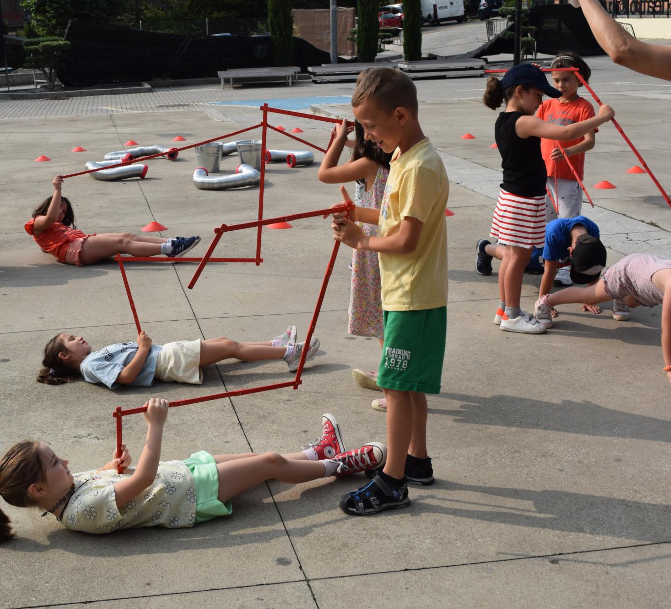 Grupo de niños jugando en la calle con grandes estructuras geométricas