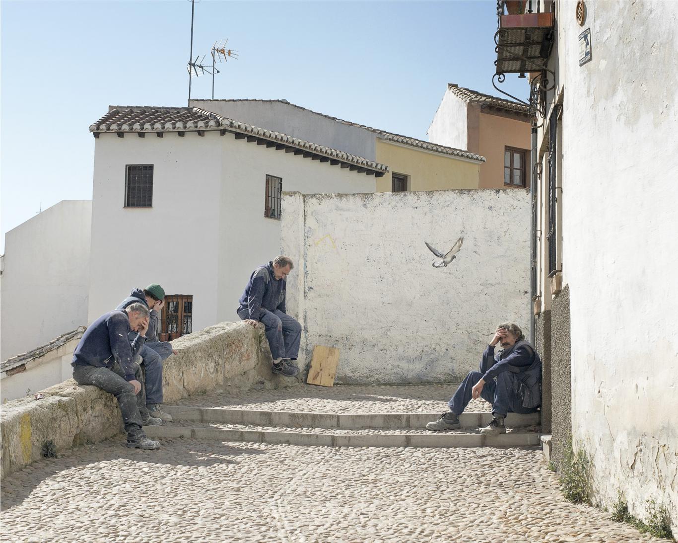 Senior men sitting on the steps of a town