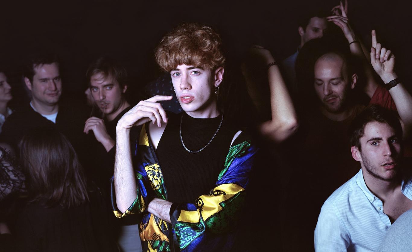 Young redhead surrounded by other young people dancing