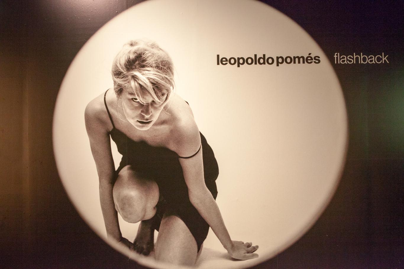 Foto de Leopoldo Pomés que es un recorte circular que enfoca a una modelo rubia arrodillada y con vestido negro que mira a la cámara