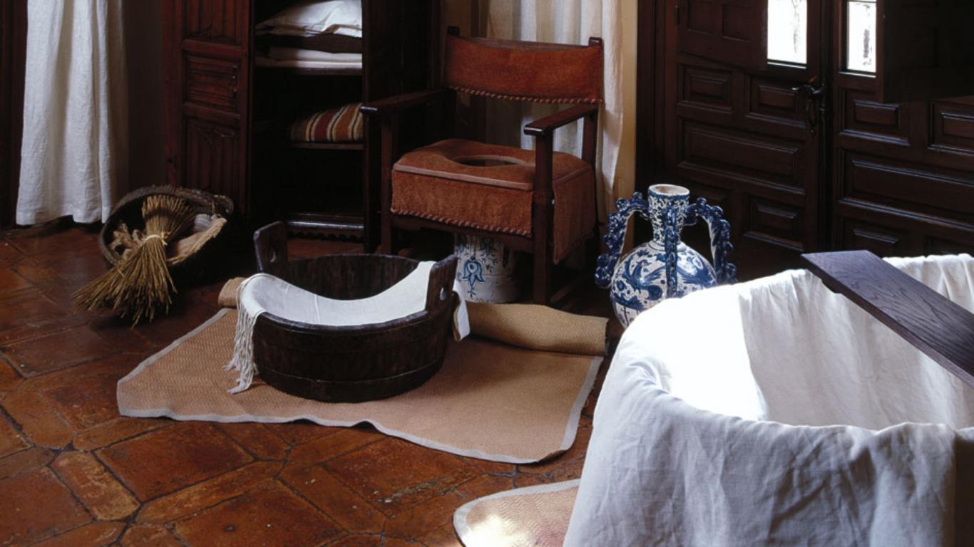 Barreño, silla para wc y toallas en una zona de higiene antigua