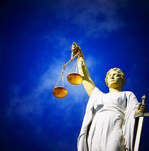 Estatua de la Justicia con una balanza dorada en una mano