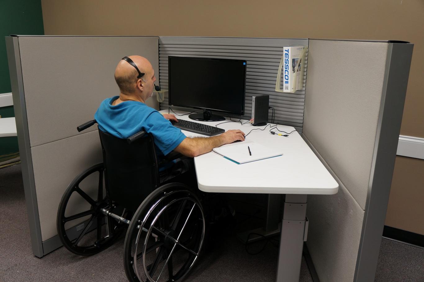 Worker in a wheelchair, working with a computer