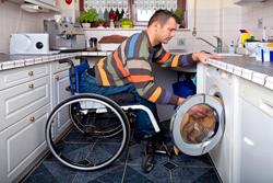 Persona con discapacidad física poniendo la lavadora