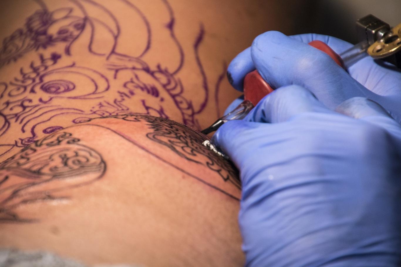 Imagen de una persona realizando un tatuaje