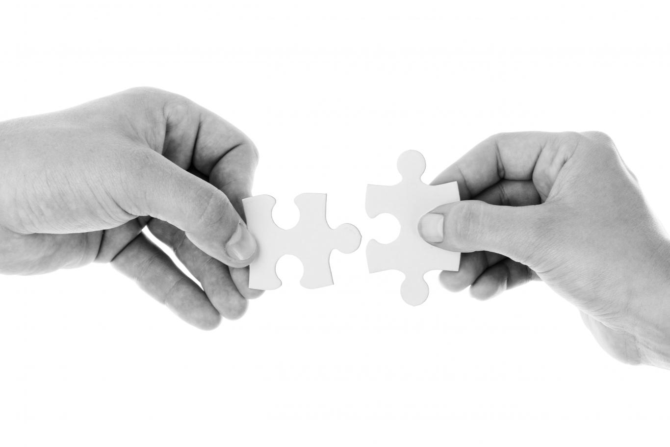 dos manos uniendo piezas de puzzle