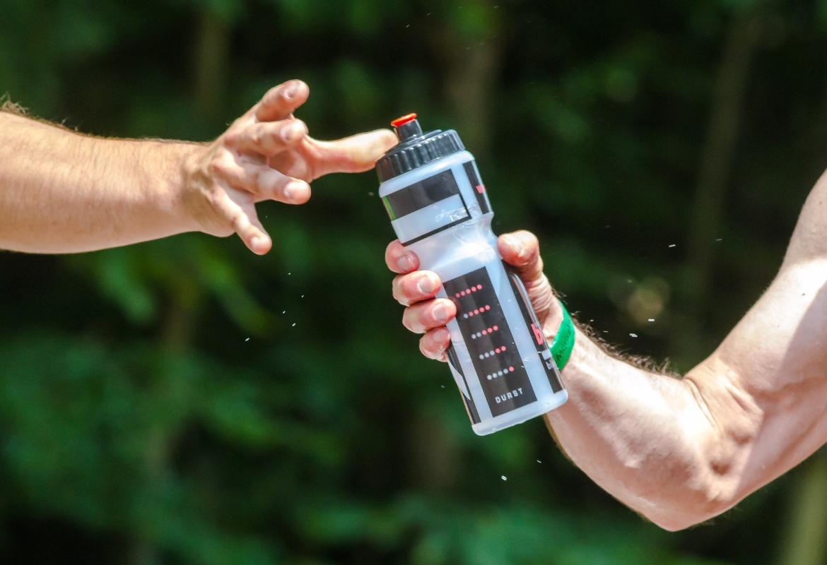 deportistas pasándose botella de agua