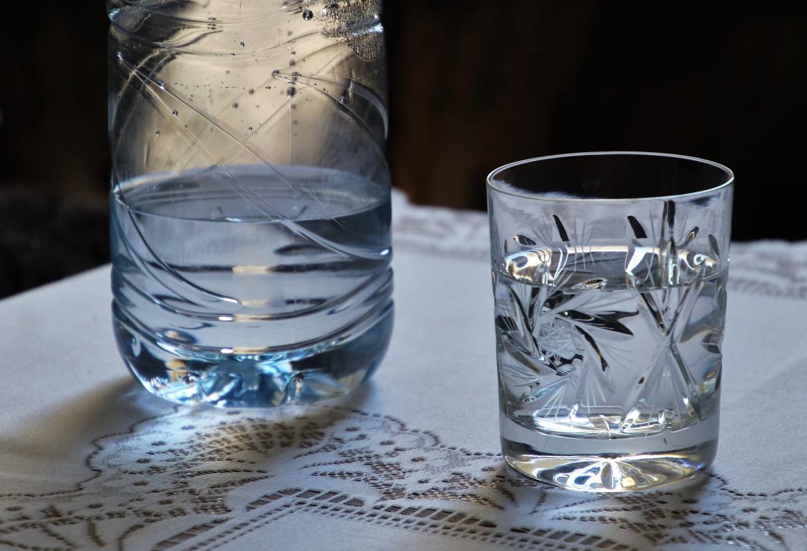 vaso de agua con botella al lado